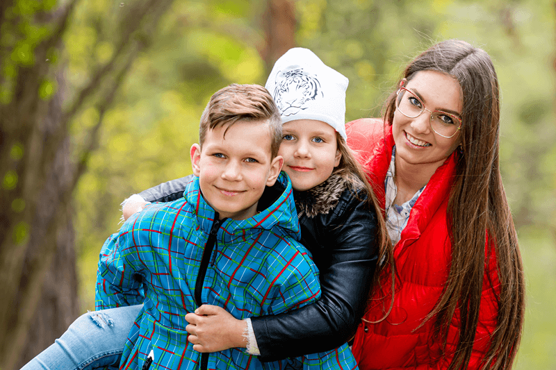 Au pair acompanhando crianças pequenas durante um momento de carinho, ilustrando o cuidado diário e o desenvolvimento emocional no intercâmbio Au Pair.
